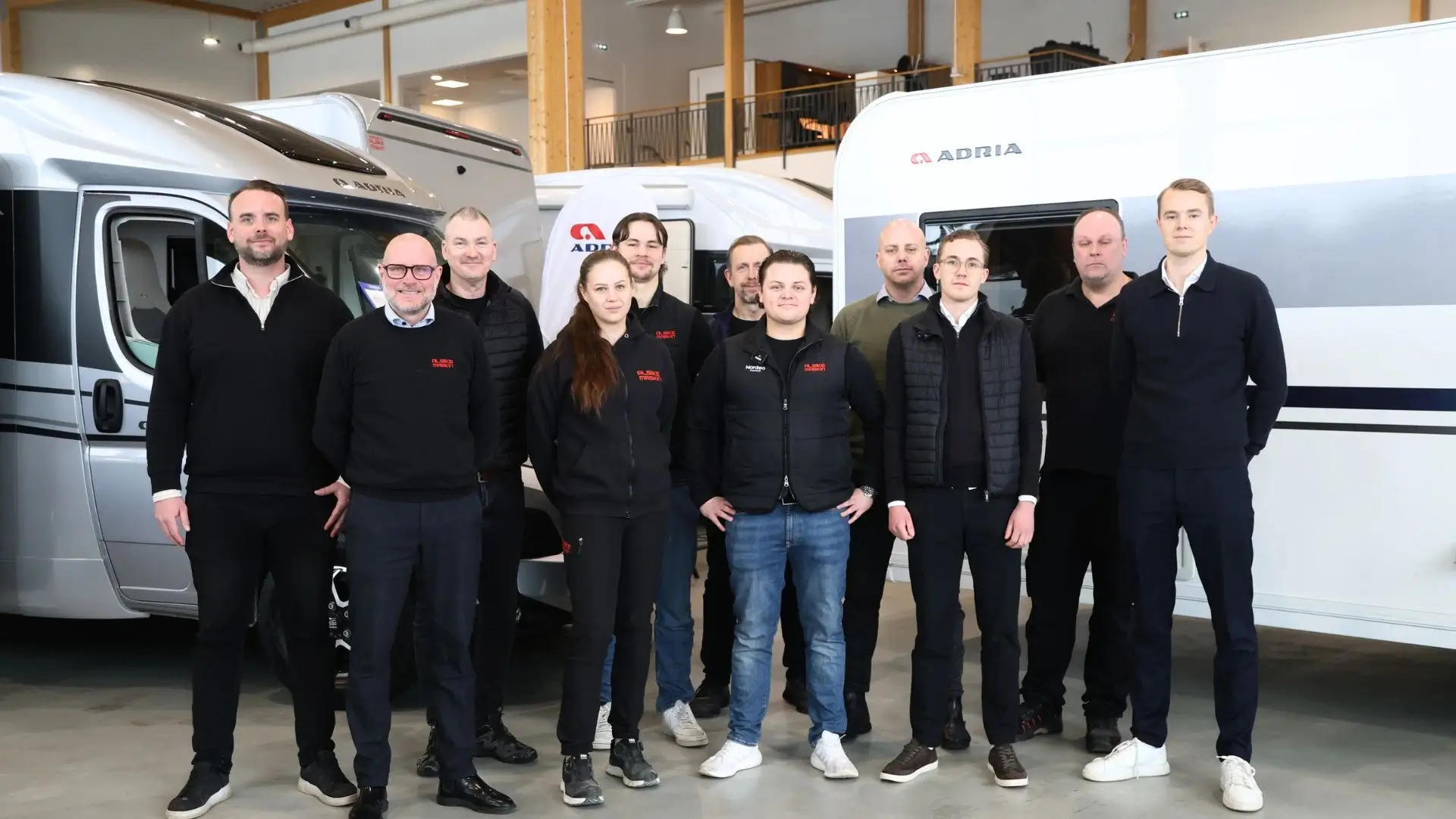 Team från Alsike Maskin framför husbilar i showroom